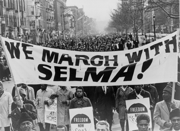 Marchers carrying banner lead the way as 15,000 parade. Photograph shows marchers carrying banner We march with Selma on street in Harlem, New York City, New York. 1965 March. ' World Telegram & Sun' photograph by Stanley Wolfson.