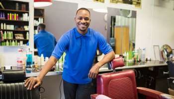 Black barber smiling in retro barbershop