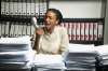 Female office worker at desk screaming into telephone receiver