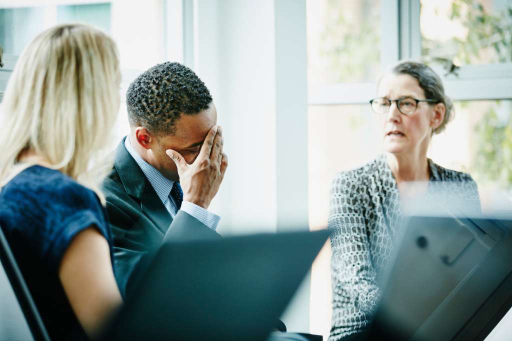 Businessman with head in hand during meeting