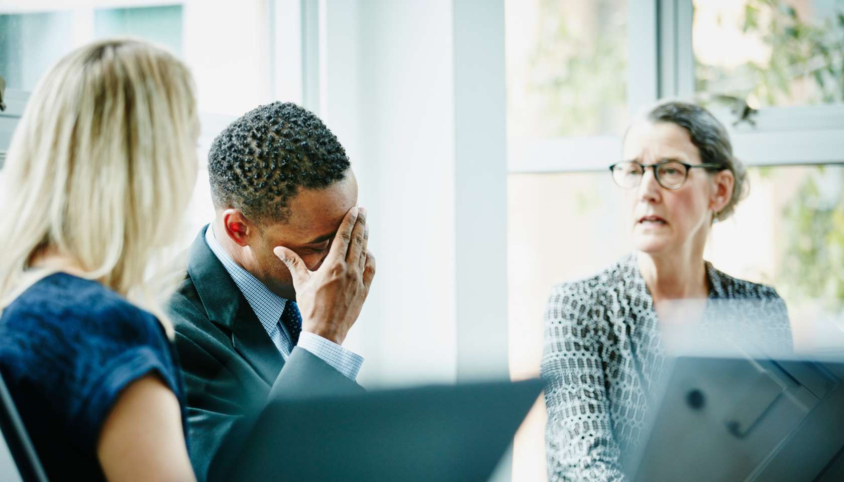 Businessman with head in hand during meeting